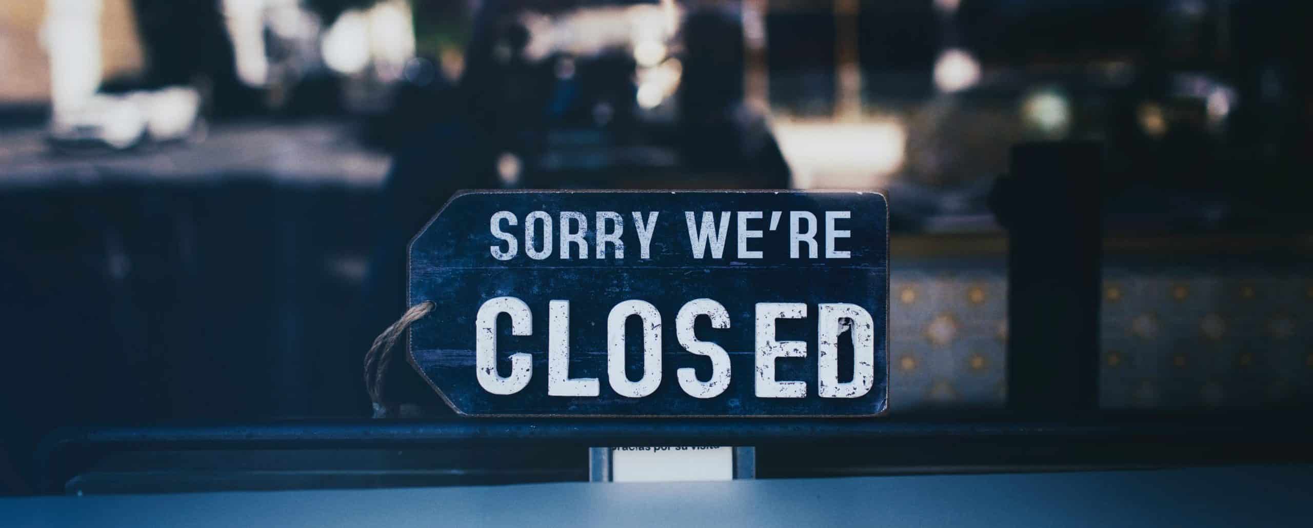 Close up photo of sorry we re closed sign on glass window 2467649 scaled e1587418402395